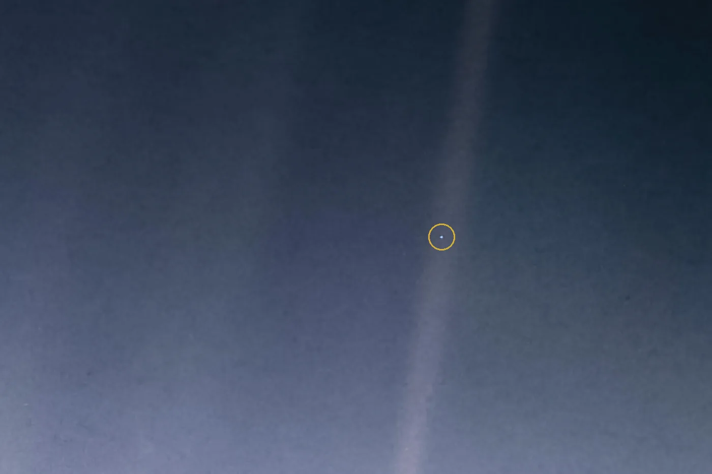 Faixa de luz solar espalhada sobre o fundo escuro do espaço, com um ponto azulado minúsculo, a Terra, marcado por um círculo dourado